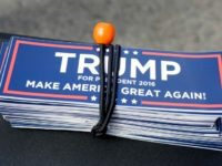 A bundle of stickers in support of Republican presidential candidate Donald Trump rest on a vendor's table before the expected start of a scheduled Trump campaign rally, Monday, April 25, 2016, in Warwick, R.I. (