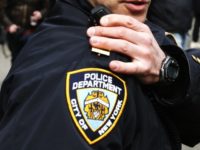 An NYPD officer talks on his radio while people take part in a protest against Republican presidential candidate Donald Trump, on March 19, 2016 in New York City.