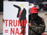 A protester holds up a sign during a protest outside the Hyatt Regency Hotel where republican presidential candidate Donald Trump was speaking in Burlingame, California on April 29, 2016.  
Hundreds of protesters jostled with police in riot gear outside a California hotel where Republican presidential frontrunner Donald Trump was to give a speech, forcing the candidate to duck into a back entrance. / AFP / Josh Edelson        (Photo credit should read JOSH EDELSON/AFP/Getty Images)