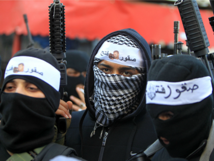 Palestinian members of Al-Aqsa Martyrs' Brigades, the armed wing of the Fatah movement, raise their weapons during a rally to support Palestinian president and his government on March 1, 2016 in the West Bank Balata refugee camp near Nablus