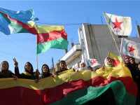SYRIA, QAMISHLI : Kurdish women hold flags of the Kurdish People's Protection Units (YPG) political wing, the Democratic Union Party (PYD), and banners during a demonstration against the exclusion of Syrian-Kurds from the Geneva talks in the northeastern Syrian city of Qamishli on February 4, 2016. The talks in Geneva are the latest bid to end Syria's conflict, nearly five years after it began in March 2011 with anti-government protests. But they have stalled over the make-up of the opposition as well as its insistence that UN resolutions on lifting sieges and protecting civilians be implemented before talks start. / AFP / DELIL SOULEIMAN