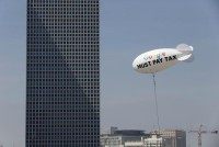 A blimp reading ''Google must pay tax'' is seen floating over the Tel Aviv skyline April 3, 2016.