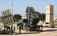 Israeli soldiers walk near an Israeli Irone Dome defence system (L), a surface-to-air missile (SAM) system, the MIM-104 Patriot (C), and an anti-ballistic missile the Arrow 3 (R) on February 25, 2016