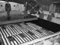 As three others stand at attention, a soldier places a wreath from Veterans of Foreign Wars, on the hold over flag-draped caskets of Americans who gave their lives during the war in Europe, following the arrival of the S.S. Lawrence Victory at the Brooklyn (N.Y.) Army Base on May 7, 1948. The vessel carried the bodies of 4,184 war dead back to the U.S. for reburial. Soldiers unidentified. (AP Photo/John Lent)