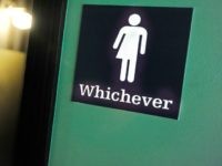 A gender neutral sign is posted outside a bathrooms at Oval Park Grill on May 11, 2016 in Durham, N.C.