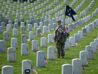 A member of the US Army looks on after placing American flags at graves at Arlington National Cemetery May 26, 2016 in Arlington, Virginia in preparation for Memorial Day. / AFP / Brendan Smialowski        (Photo credit should read BRENDAN SMIALOWSKI/AFP/Getty Images)