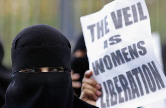 BLACKBURN, UNITED KINGDOM - OCTOBER 14: A Muslim woman wearing a niqab veil protests outside Bangor Street Community centre where Leader of the House of Commons Jack Straw is holding one of his weekend surgery appointments where he faced a protest by around 50 Muslim protesters on October 14, 2006, Blackburn, England. Jack Straw made comments last week regarding his view that veils such as the Burqa and Niqab split communities. (Photo by Christopher Furlong/Getty Images)