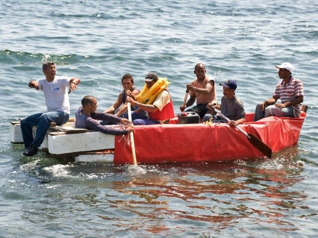 Seven would-be Cuban emigres remain in a homemade boat moments before being arrested by Cuban military agents after their attempt to escape from the island nation was thwarted by the sea currents, on June 4, 2009 in Havana. The boat-people's raft was brought back to the coast just in front of the US Interest Section office in Havana as they tried to cross the shark-infested Florida Straits. The United States, in another move aimed at thawing relations with Cuba, has offered to resume migration talks with the communist-ruled island almost six years after they were suspended. AFP PHOTO/ADALBERTO ROQUE
