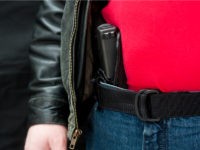 'A modern, polymer (Glock), .45 caliber semiautomatic pistol in an IWB holster under a leather jacket.All images in this series...'