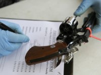 A Miami detective registers a Colt .357 Magnum than was turned in during a gun buyback program held at the Jordan Grove Missionary Baptist Church, Saturday, March 12, 2016, in Miami. The event was organized by Rev. Jerome Starling in response to continuing gun violence in the city. Over 100 firearms were collected. (AP Photo/Lynne Sladky)