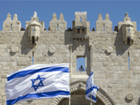 Israeli youths wave their national flag as they take part in the 'flag march' through Damascus Gate in Jerusalem's old city during celebrations for Jerusalem Day on May 17, 2015 which marks the anniversary of the 'reunification' of the holy city after Israel captured the Arab eastern sector from Jordan during the 1967 Six-Day War.
