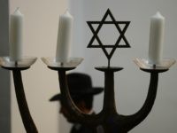 A man walks past a menorah during a ceremony to ordain four rabbis at the synagogue in Cologne, western Germany, on September 13, 2012