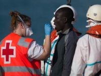 A man is attended by a Red Cross nurse on arrival into the southern Spanish port of Malaga on May 19, 2016 after an inflatable boat carrying 52 Africans, ten of them women, was rescued by the Spanish coast guard off the Spanish coast.