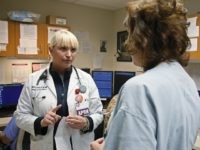 Jennifer Parrott, a certified nurse practitioner, left, talks with a doctor about a patient at the Oklahoma Health Sciences Emergency Department, in Oklahoma City, in Oklahoma City, Friday, May 13, 2016. Republican leaders in Oklahoma are moving toward a plan to expand its Medicaid program to bring in billions of federal dollars from President Obama's new health care system. (AP Photo/Sue Ogrocki)