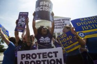 Pro-choice activists celebrate during a rally at the Supreme Court in Washington, Monday, June 27, 2016, after the court struck down Texas' widely replicated regulation of abortion clinics. The justices voted 5-3 in favor of Texas clinics that had argued the regulations were a thinly veiled attempt to make it harder for women to get an abortion in the nation's second-most populous state. (AP Photo/Evan Vucci)