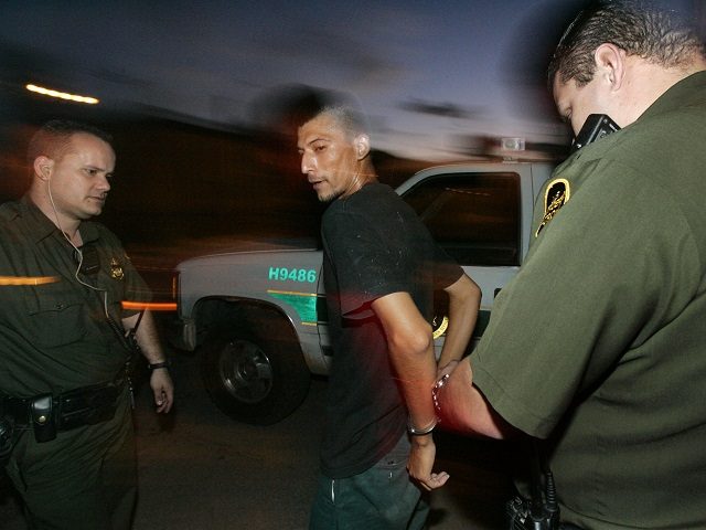 NOGALES, AZ - AUGUST 30:  U.S. Border Patrol agents apprehend an illegal alien caught crossing the border August 30, 2005 in Nogales, Arizona. The governors of New Mexico and Arizona have declared a state of emergency along the border due to drug trafficking, illegal immigration and terrorism.  (Photo by Sandy Huffaker/Getty Images)