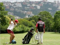 A member of the Country Club plays golf as his caddy stands by in Caracas, Venezuela, Tuesday, Aug. 29, 2006. The city mayor's office has decreed the expropriation of all three major golf courses in Caracas under eminent domain. (AP Photo/Leslie Mazoch)