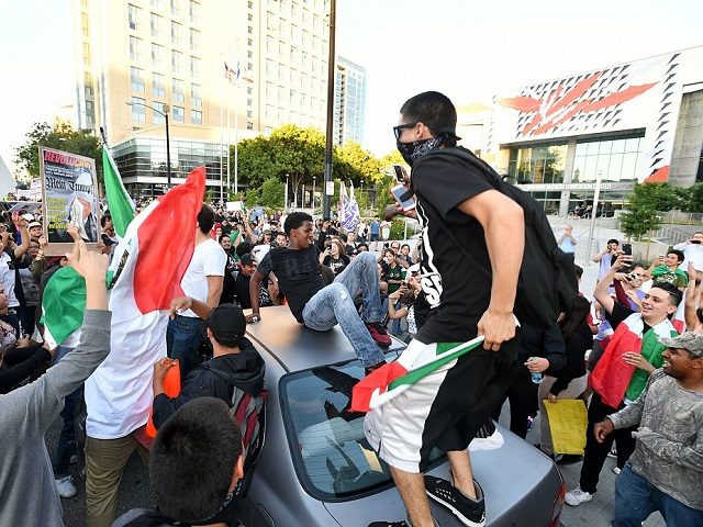 Protesters climb atop a car stopped in traffic as a crowd marches near the venue where Republican presidential candidate Donald Trump was speaking during a rally in San Jose, California on June 2, 2016. 
Protesters who oppose Donald Trump scuffled with his supporters on June 2 as the presumptive Republican presidential nominee held a rally in California, with fistfights erupting and one supporter hit with an egg. / AFP / JOSH EDELSON        (Photo credit should read JOSH EDELSON/AFP/Getty Images)