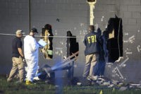 FBI agents investigate near the damaged rear wall of the Pulse Nightclub where Omar Mateen allegedly killed at least 50 people on June 12, 2016 in Orlando, Florida.