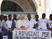 Pope Francis poses surrounded by a group of refugees attending his weekly general audience at St Peter's square on June 22, 2016 in Vatican. The banner reads : "For a Future all together" / AFP / TIZIANA FABI        (Photo credit should read TIZIANA FABI/AFP/Getty Images)