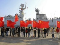 Chinese nationals living in Cyprus wave Chinese national flags as the Chinese frigate Yancheng comes in to dock at Limassol port, January 4, 2014. REUTERS/ANDREAS MANOLIS