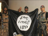 In this image taken by an Iraqi Counterterrorism Service photographer on Sunday, June 19, 2016, soldiers pose with an Islamic State militant flag in Fallujah, Iraq after forces re-took the city center after two years of IS control. Thousands of civilians are fleeing Fallujah after the city was declared liberated from the Islamic State group, the United Nations said, while an Iraqi commander reported fierce clashes as elite counterterrorism forces pushed to clear out the remaining militants. (Iraq Counterterrorism Service via AP)