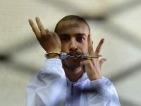 Egyptian Copt Albert Saber, 27, flashes the V for 'victory' sign from inside the holding cage during the opening session of his trial in Cairo on September 26, 2012, on charges of blasphemy, insulting religions and inciting sectarianism through his Internet postings.