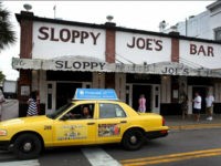 KEY WEST, FL - SEPTEMBER 12: A taxi drives past Sloppy Joe's Bar on Duval Street on September 12, 2013 in Key West, Florida. The city recently enacted a Key West City Ordinance that will allow taxi cab drivers to charge $50 over the price of the cab ride to an intoxicated person who vomits in a cab. The fine would be levied against an intoxicated passenger but not children or sober riders who become ill. (Photo by Joe Raedle/Getty Images)
