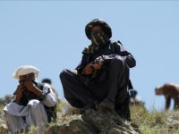 In this Friday, May 27, 2016 photo, Taliban fighters guard as senior leader of a breakaway faction of the Taliban Mullah Abdul Manan Niazi, not pictured, delivers a speech to his fighters, in Shindand district of Herat province, Afghanistan. In the rugged terrain of the Taliban heartland in southern Afghanistan, the fight against Kabul has become a war for control of key stretches of main roads and highways as the insurgents use a new tactic to gain ground. (AP Photos/Allauddin Khan)