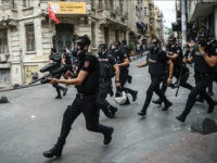 Turkish anti riot police officers fire rubber bullets to disperse demonstrators gathered for a rally staged by the LGBT community on Istiklal avenue in Istanbul on June 26, 2016. Riot police fired tear gas and rubber bullets to disperse protesters defying a ban on the city's Gay Pride parade. Authorities in Turkey's biggest city had banned the annual parade earlier this month citing security reasons, sparking anger from gay rights activists. / AFP / OZAN KOSE (Photo credit should read OZAN KOSE/AFP/Getty Images)
