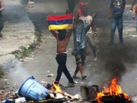 'La Vega' low income neighborhood residents clash with riot police during a demonstration in Caracas on June 10, 2016. Facing mounting pressure from food shortages, looting and increasingly violent protests, Venezuelan authorities on Friday announced the next stage for a recall referendum against embattled President Nicolas Maduro. / AFP / STR (Photo credit should read STR/AFP/Getty Images)