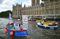 A Brexit flotilla of fishing boats passes the Houses of Parliament as it sails up the river Thames in London on June 15, 2016
