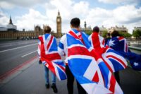 People walk over Westminster Bridge wrapped in Union flags, towards the Queen Elizabeth Tower (Big Ben) and The Houses of Parliament in London on June 26, 2016