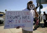 An anti-Trump protester chants at an intersection a block away from the Arizona Veterans Memorial Coliseum in Phoenix, Ariz., where Donald Trump spoke on Saturday, June 18, 2016. Several dozen protestors gathered outside in temperatures in that peaked at 111 degrees.Donald Trump railed Saturday against efforts by some frustrated Republicans planning a last-ditch effort to try to thwart him from becoming the party's nominee, threatening at one point to stop fundraising if Republicans don't rally around him. (AP Photo/Beatriz Costa-Lima)