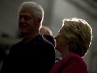 Former President Bill Clinton, left, and Democratic presidential candidate Hillary Clinton, right, are silhouetted by a light as they attend a factory tour of K'NEX, a toy company, in Hatfield, Pa., Friday, July 29, 2016. Clinton and Kaine begin a three day bus tour through the rust belt. (AP Photo/Andrew Harnik)