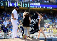 LOS ANGELES, CA - JULY 03:  Protestors interupt the game as Kenley Jansen #74 of the Los Angeles Dodgers waits on the mound during the ninth inning against the Colorado Rockies at Dodger Stadium on July 3, 2016 in Los Angeles, California.  (Photo by Harry How/Getty Images)