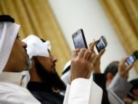 Kuwaitis use their mobile phone to follow the press conference for Kuwaiti MP's after the end of the Kuwaiti PM grilling session at the Kuwaits National Assembly in Kuwait City on December 28, 2010.