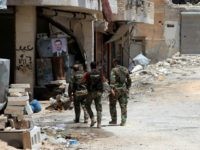 Syrian army soldiers patrol in government-controlled Aleppo's al-Khalidiya area where the army progressed towards the industrial zone of al-Layramoun and Bani Zeid on June 28, 2016. Aleppo was once the country's commercial hub but now lies divided between government forces in the west and rebels in the east. / AFP / GEORGES OURFALIAN (Photo credit should read GEORGES OURFALIAN/AFP/Getty Images)