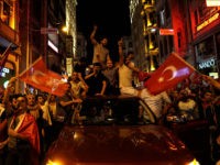 People chant slogans during a pro-government rally in central Istanbul's Taksim square, Saturday, July 16, 2016. Forces loyal to Turkish President Recep Tayyip Erdogan quashed a coup attempt in a night of explosions, air battles and gunfire that left some hundreds of people dead and scores of others wounded Saturday. (AP Photo/Bram Janssen)