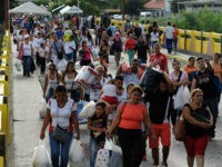 Venezuela, San Antonio del Táchira : Venezuelans carrying groceries cross the Simon Bolivar bridge from Cucuta in Colombia back to San Antonio de Tachira in Venezuela, on July 10, 2016. Thousands of Venezuelans crossed Sunday the border with Colombia to take advantage of its 12-hour opening after it was closed by the Venezuelan government 11 months ago. Venezuelans rushed to Cucuta to buy food and medicines which are scarce in their country. / AFP PHOTO / GEORGE CASTELLANOS