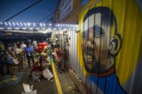 Protesters gather in front of a mural of Alton Sterling on the wall of a convenience store in Baton Rouge, Louisianna where Sterling was shot dead by police