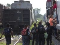In this Saturday, July 12, 2014, photo, migrants run to jump on a train during their journey toward the U.S.-Mexico border, in Ixtepec, Mexico. The migrants pay thousands of dollars per person for the illegal journey across thousands of miles in the care of smuggling networks that in turn pay off government officials, gangs operating on trains and drug cartels controlling the routes north.  (AP Photo/Eduardo Verdugo)