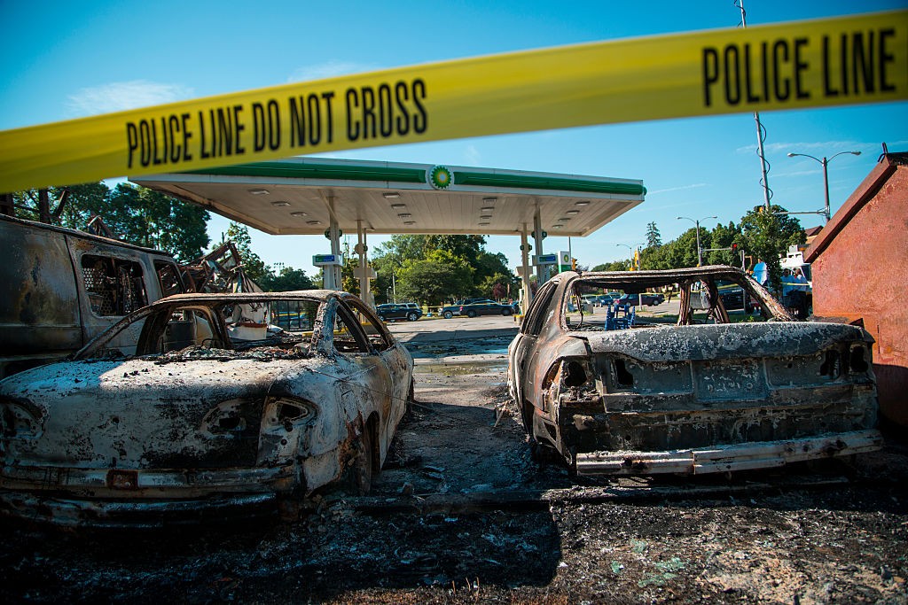MILWAUKEE, WI - AUGUST 14: Cars stand burned in the lot of the BP gas station after rioters clashed with the Milwaukee Police Department protesting an officer involved killing August 14, 2016 in Milwaukee, Wisconsin. Hundreds of angry people confronted police after an officer shot and killed a fleeing armed man earlier in the day. (Photo by Darren Hauck/Getty Images)