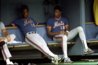 PITTSBURGH - AUGUST 1984:  Pitcher Dwight Gooden #16 and outfielder Darryl Strawberry #18 of the New York Mets look on from the dugout during a game against the Pittsburgh Pirates at Three Rivers Stadium in August 1984 in Pittsburgh, Pennsylvania. (Photo by George Gojkovich/Getty Images)