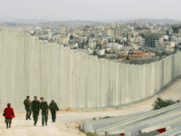 Israeli soldiers patrol along the concrete separation barrier bordering Abu Dis, West Bank March 26, 2006 in East Jerusalem, Israel. The controversial separation barrier blocks direct access between the West Bank and Israel and will eventually separate Jerusalem from the West Bank. The wall, Israel claims, is the most effective tool to keep out Palestinian terrorists and continues to be an ongoing politcal issue as Israelis go to the polls in the upcoming March 28 general elections. (Photo by Paula Bronstein/Getty Images)