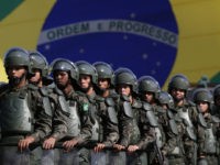 FILE - In this July 22, 2016 photo, Brazilian Army soldiers take part in military exercise during presentation of the security forces for the Rio 2016 Olympic Games, in front of the National Stadium, in Brasilia, Brazil. Security has emerged as the top concern during the Olympics, including violence possibly spilling over from Rio's hundreds of slums. Authorities have said 85,000 police officers and soldiers will be patrolling during the competitions. (AP Photo/Eraldo Peres, File)