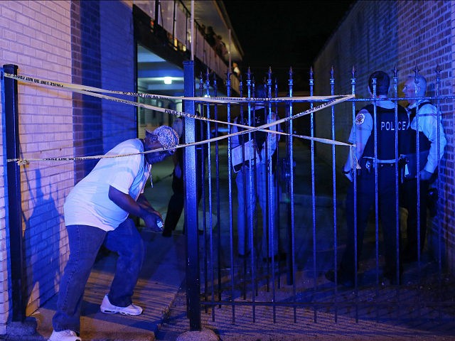 A resident ducks under crime scene tape after retrieving medication from his apartment, as officers guard the area of a police-involved shooting in the apartment complex, on the 1800 block of East 87th Street early Sunday, July 10, 2016, in Chicago. A man in a second floor unit was shot in the leg by an officer after refusing to put down what appeared to be a handgun, according to Chief of Detectives Eugene Roy. (John J. Kim/Chicago Tribune/TNS via Getty Images)