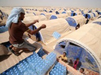 Displaced Iraqis who fled the government's operation against the Islamic State (IS) group in the city of Fallujah collect water bottles donated by a NGO called Preemptive Love Coalition amidst a dust storm on June 20, 2016 in a camp in Khaldiyeh. They fled starvation and jihadist tyranny in Fallujah for the safety of displacement camps but thousands of Iraqi families still have nothing to eat and nowhere to sleep. More than 60,000 people have been forced from their homes in the area over the past month and a sudden influx of civilians pouring out of the city centre last week has left the aid community unable to cope. / AFP / HAIDAR MOHAMMED ALI (Photo credit should read HAIDAR MOHAMMED ALI/AFP/Getty Images)