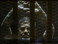Ousted Egyptian president Mohamed Morsi gestures from the defendants cage as he attends his trial at the police academy on the outskirts of the capital Cairo on June 2, 2015. The Egyptian court postponed its final ruling on Morsi, who was sentenced to death along with dozens more over a mass jailbreak during the 2011 uprising. AFP PHOTO / KHALED DESOUKI (Photo credit should read KHALED DESOUKI/AFP/Getty Images)
