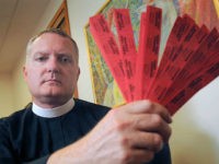 In this July 27, 2016 photo, Rev. Jeremy Lucas of Christ Church Episcopal Parish holds the 150 tickets that he purchased in an all-star softball team's raffle to win an AR-15 assault rifle in Lake Oswego, Ore. Lucas may have run afoul of Oregon law when he transferred the assault rifle, which he says he tried to win in order to destroy it, to a friend for safekeeping without performing a background check. (Vern Uyetake/Lake Oswego Review via AP)